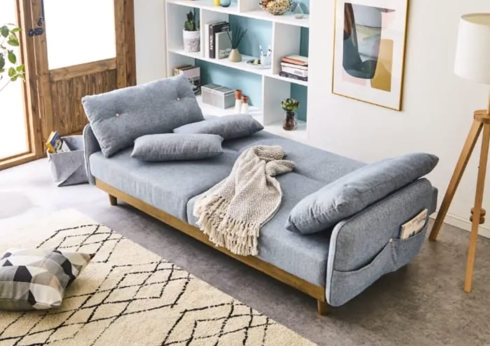 写真；室内に置かれたソファベッド。ベッドに変形させた状態。