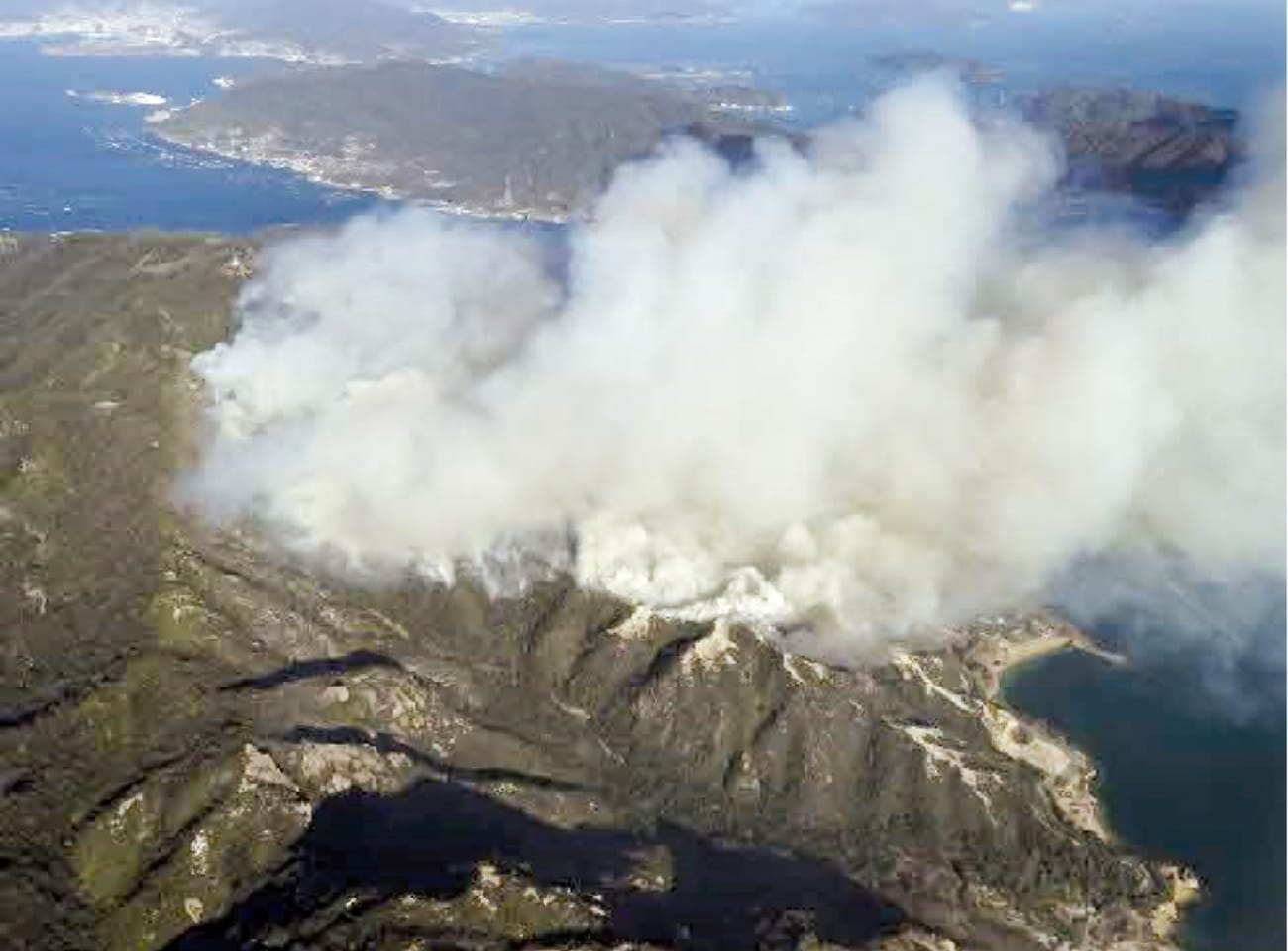 山火事の写真：山の広範囲から白い煙が上がっている
